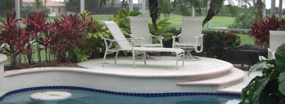 A pool with chairs and tables by the side of it